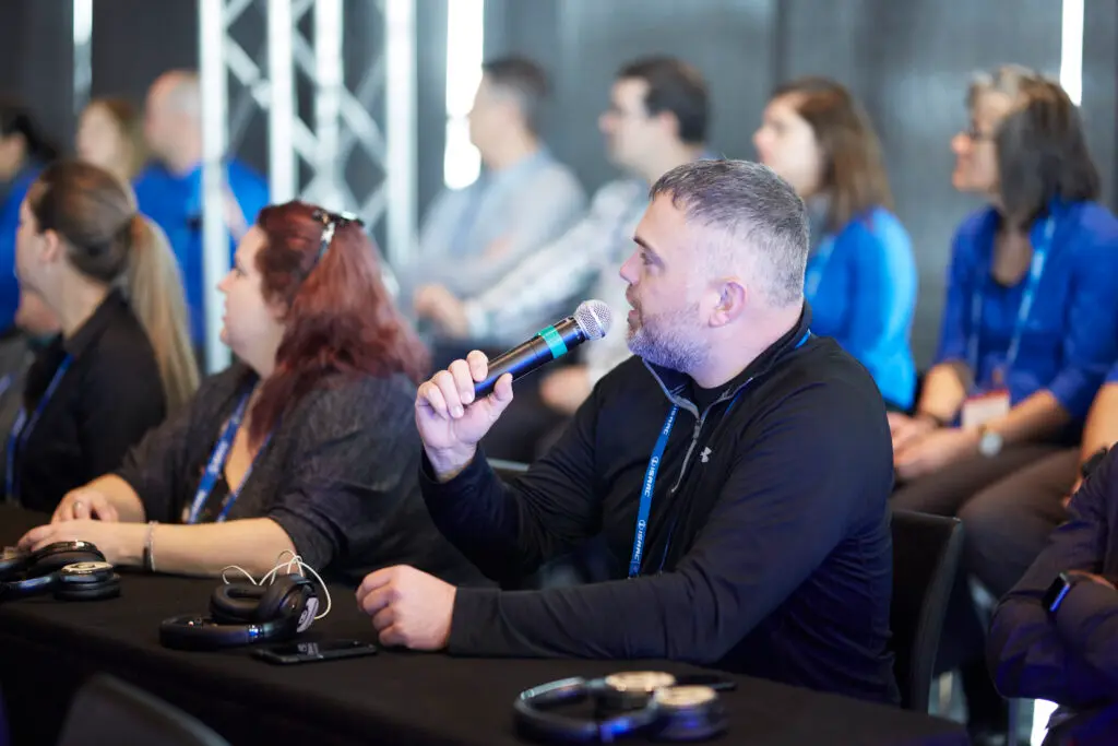 Audience member speaking into a microphone during a collaborative ISAAC conference session
